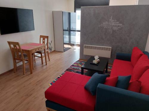 salon z czerwoną kanapą i stołem w obiekcie DOUBLE Studio w mieście Rabat