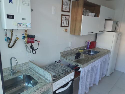 uma pequena cozinha com um fogão e um lavatório em AP encantador na Praia do Forte! (208) em Cabo Frio