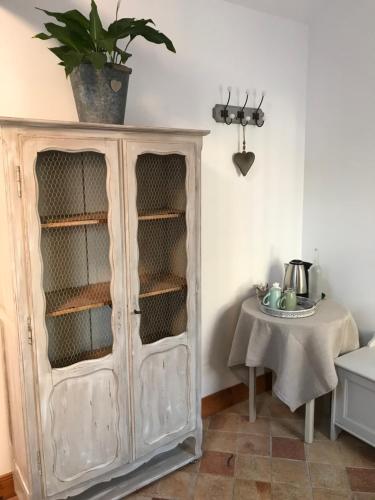 um armário com uma planta em cima dele ao lado de uma mesa em Chambres Beauvais em Beauvais