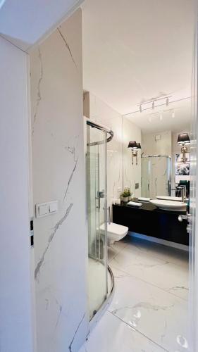 a bathroom with a glass shower and a toilet at Rudnickiego, Fort Bema, free parking by Cosmo Spirit in Warsaw