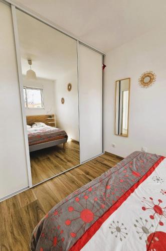 - une chambre avec un miroir et un lit dans l'établissement La Petite Maison du Bassin d'Arcachon - 40 m2, climatisée, indépendante et au calme, à Audenge