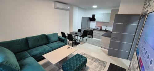 a living room with a green couch and a kitchen at Djurdjevik Home in Živinice