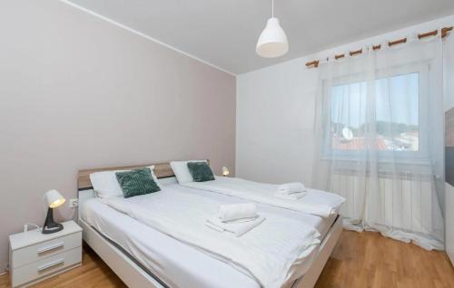 um quarto branco com uma cama grande e uma janela em Apartment near the center/beach em Pula