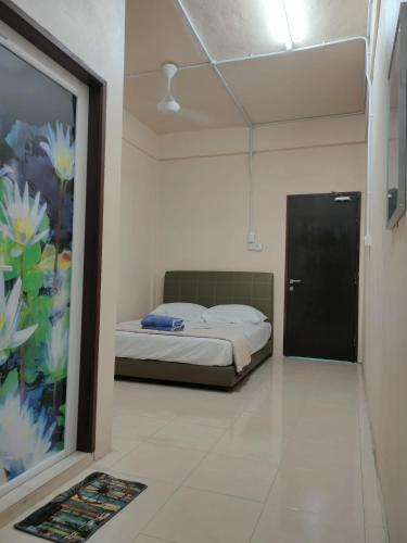 a bedroom with a bed and a door with a painting at RS INN in Rantau Panjang
