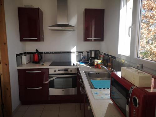 une cuisine avec un évier et une cuisinière dans l'établissement PLEHEREL PLAGE Location saisonnière 4-5 personnes, à Fréhel