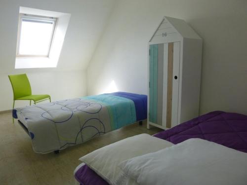 a bedroom with two beds and a small cabinet at PLEHEREL PLAGE Location saisonnière 4-5 personnes in Frehel