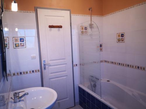 a bathroom with a sink and a shower and a tub at PLEHEREL PLAGE Location saisonnière 4-5 personnes in Frehel