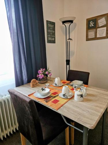 a wooden table with tea sets on top of it at Apartment Jackie in Bielefeld