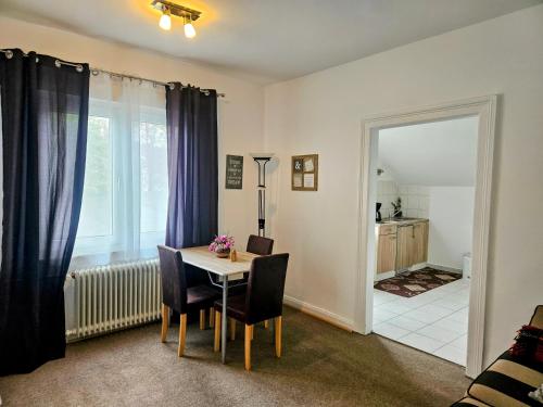 d'une salle à manger avec une table, des chaises et une fenêtre. dans l'établissement Apartment Jackie, à Bielefeld