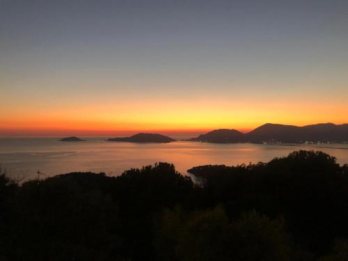 a sunset over a body of water with mountains at La Corinna in Lerici