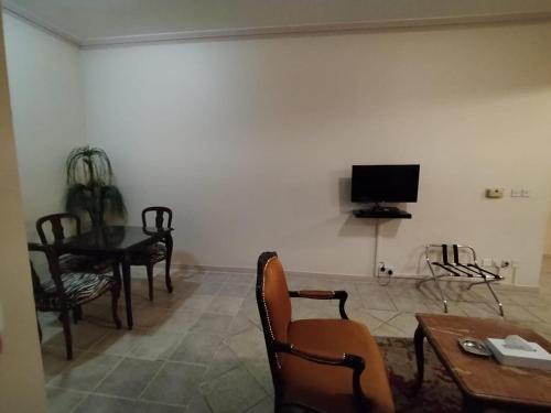 uma sala de estar com uma mesa e cadeiras e uma televisão em شقق الفرسان حي السلامة em Jidá