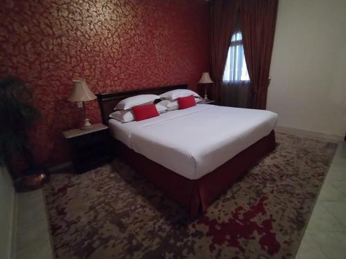 a bedroom with a large bed with red walls at شقق الفرسان حي السلامة in Jeddah