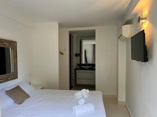 um quarto com uma cama branca e toalhas em Maison d' Orange - Chambres em Saint-Tropez