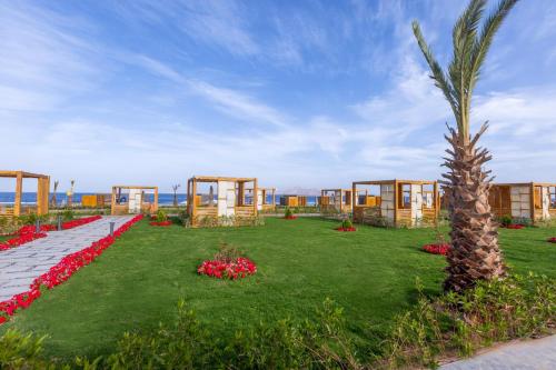 a resort with a palm tree and flowers in the grass at Rixos Radamis Sharm El Sheikh in Sharm El Sheikh