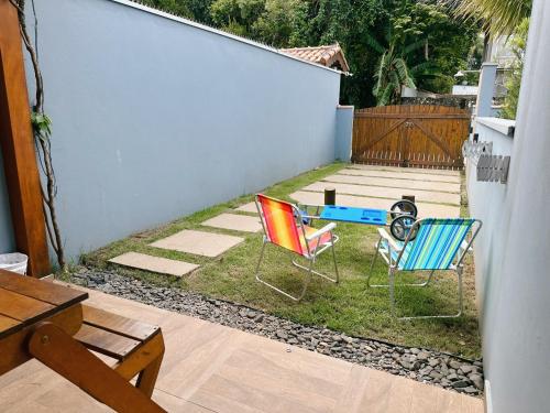 two chairs and a table in a yard at Casinhas Terõ - in São Sebastião