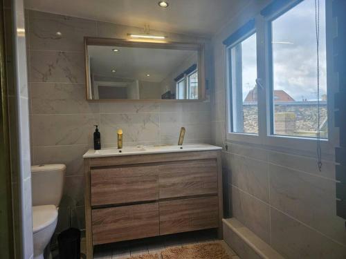 een badkamer met een wastafel en een toilet en een raam bij Le duplex Clieu BY HOLIDIEPPE in Dieppe