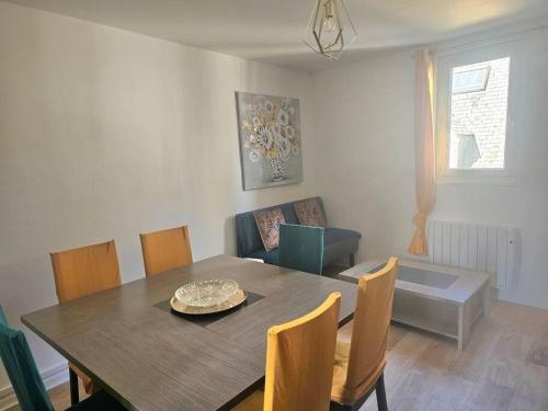 une salle à manger avec une table et des chaises en bois dans l'établissement Le duplex Clieu, à Dieppe