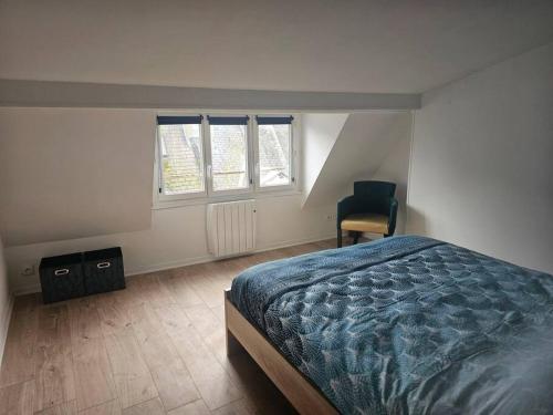 een slaapkamer met een bed en een stoel en 2 ramen bij Le duplex Clieu BY HOLIDIEPPE in Dieppe