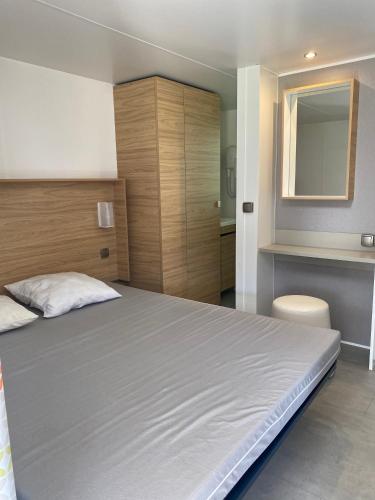 une chambre avec un grand lit et un miroir dans l'établissement Location de vacances en campagne avec accès piscine, à Beaucaire
