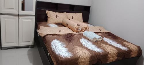 Una cama con mantas y almohadas. en Mutiara Homestay Jogja, en Ngingas
