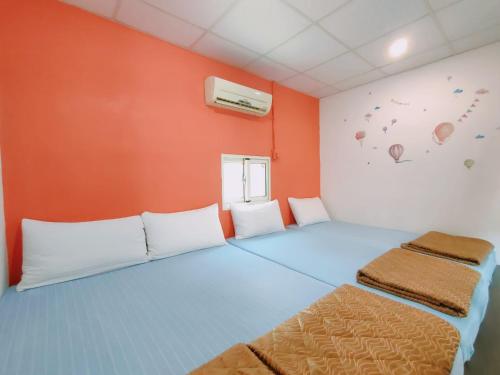 a room with a blue bed and an orange wall at 小琉球陽光藍海民宿 in Xiaoliuqiu
