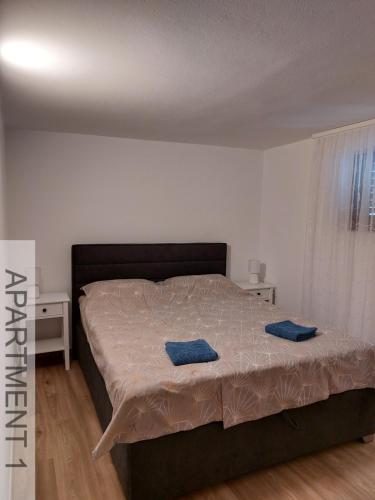 um quarto com uma cama com duas almofadas azuis em Apartmani Denis em Stara Baška