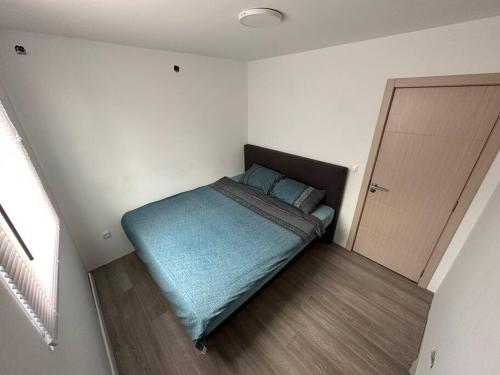 - une petite chambre avec un lit et une couverture bleue dans l'établissement Modular House New Belgrade, à Belgrade