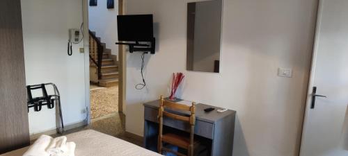 Habitación con TV y espejo en la pared. en Hotel Moranna, en Lido di Camaiore