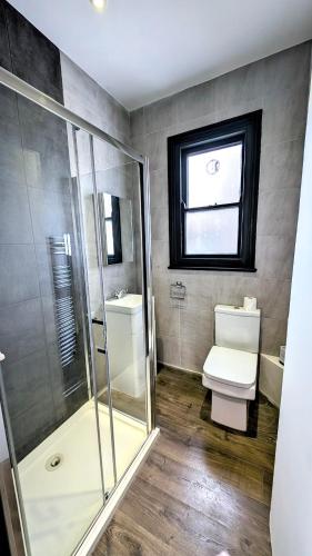 a bathroom with a shower and a toilet and a window at INNit Bliss in Brighton & Hove
