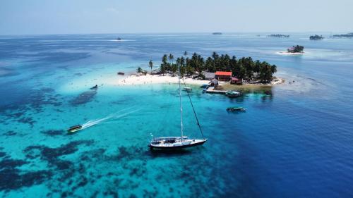 an island with a sail boat in the water at 73ft Family Sailing Yacht with Crew - all inclusive in Waisalatupo