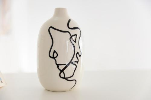 a white vase with black lines on it at Al 26 Apartment in Erice