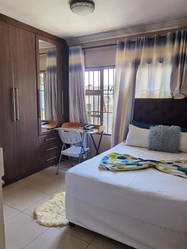 a bedroom with a bed and a table and a desk at Alimop Bed and Breakfast in Midrand