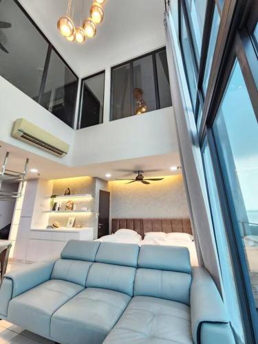 a living room with a blue couch in a bedroom at 2-6Pax Luxury Almas Duplex Suite Legoland near JB & Tuas in Nusajaya
