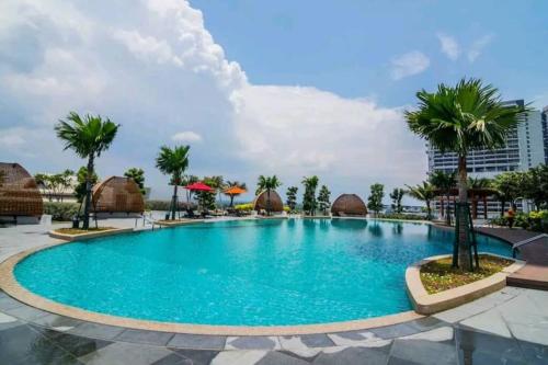 a swimming pool at a resort with palm trees at 2-6Pax Luxury Almas Duplex Suite Legoland near JB & Tuas in Nusajaya