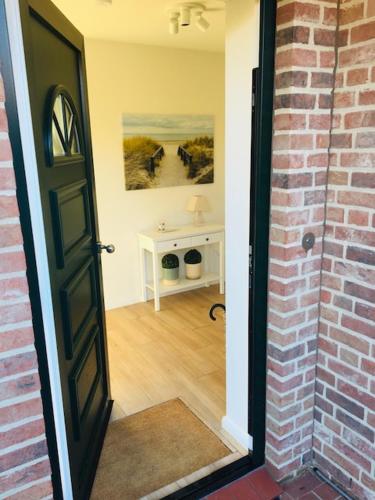 an open door to a room with a brick wall at Ferienhaus Wiesenkate in Hohwacht
