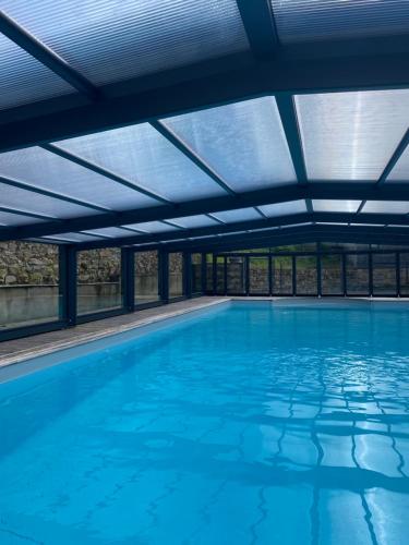 an indoor swimming pool with a ceiling of blue water at Maison d'hôtes & Gîtes Domaine de la Garaye in Dinan