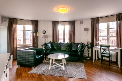 a living room with a green couch and a table at Ars Vivendi Rezidence in Rīga