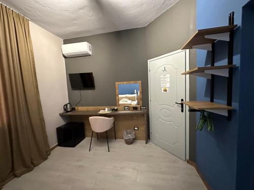 a room with a desk and a white door and a chair at VILLA CABARE Apartments&Rooms in Durrës