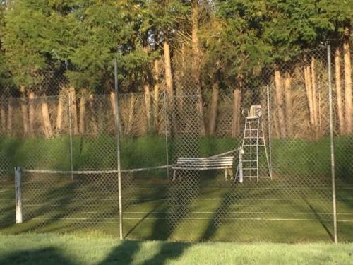 un court de tennis avec un banc et une échelle dans l'établissement Gris Pomme Gite du Manoir de la Porte, à Les Authieux-sur-Calonne