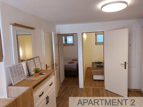 a room with a desk and a bedroom at Apartmani Denis in Stara Baška