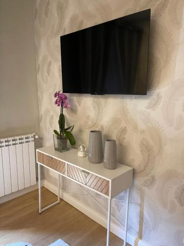 una mesa blanca con TV en la pared en Il Borghetto en Mentana
