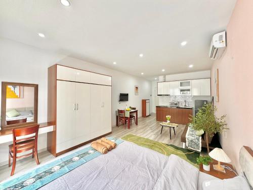 a living room with a couch and a kitchen at The Little Home - Cù Chính Lan - Modern & Comfy Apartment in Hanoi