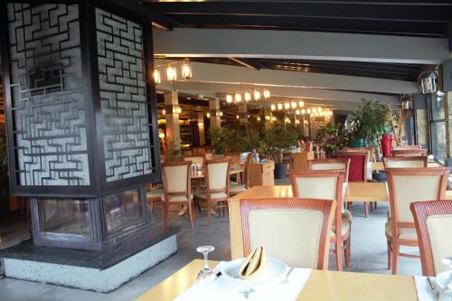 restauracja ze stołami i krzesłami oraz kominkiem w obiekcie Gölevi Resort Sapanca w mieście Sapanca
