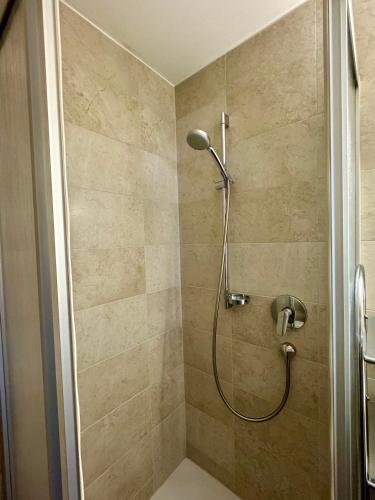 a shower with a shower head in a bathroom at SKILL Mountain Lodge - Ski und Bike Hostel im Sommer mit JOKER CARD in Saalbach Hinterglemm