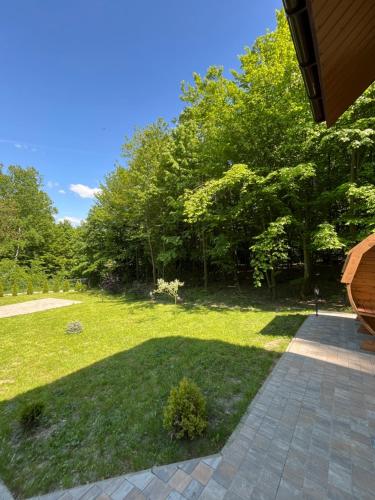 a yard with grass and trees and a walkway at Domek w lesie Sauna i Gorąca balia Wellness&Spa in Grybów