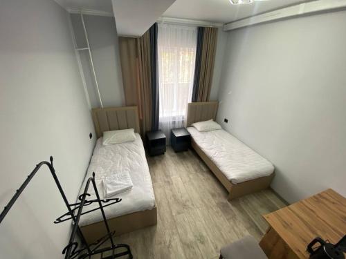 a room with two beds and a table in it at Bagysh Hotel in Kochkor