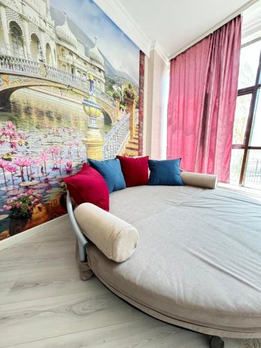 een slaapkamer met een bed met een schilderij aan de muur bij Люкс апартаменты в Актобе in Aqtöbe