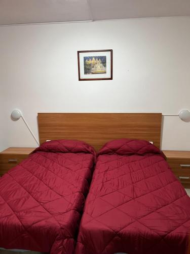 リョレート・デ・マルにあるLinda Appartamento Lloretのベッドルームに赤い掛け布団付きのベッド1台