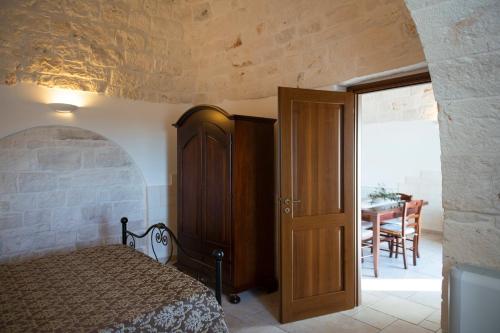 a bedroom with a bed and a dining room with a table at Trulli Magravì - Apparthotel in Alberobello