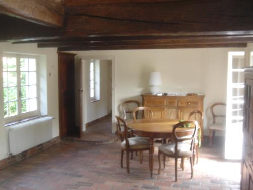 une salle à manger avec une table et des chaises en bois dans l'établissement les ormeaux, à Ambleteuse